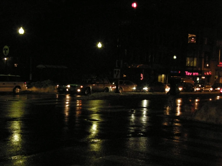 cars wait for the signal light to change at night