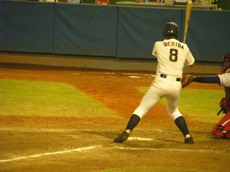 a baseball player gets ready to hit the ball while the catcher and umpire watch