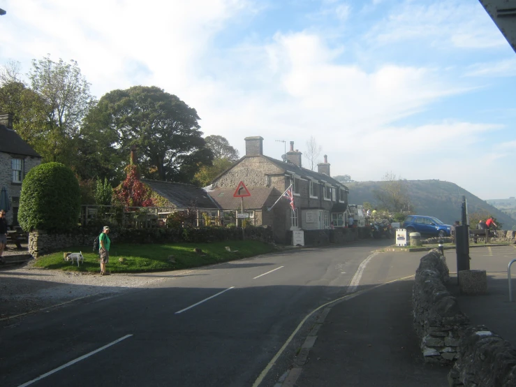 the people are walking through a village near the road