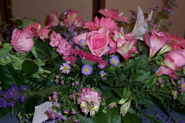 there is a table full of flowers and greenery