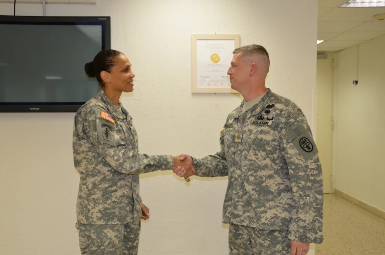 two people in uniform are shaking hands