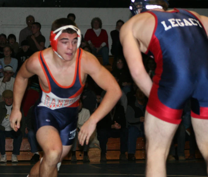 two wrestling wrestlers standing in the middle of a match