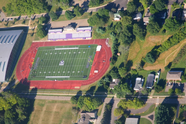 an aerial s of a stadium with grass on the field and trees