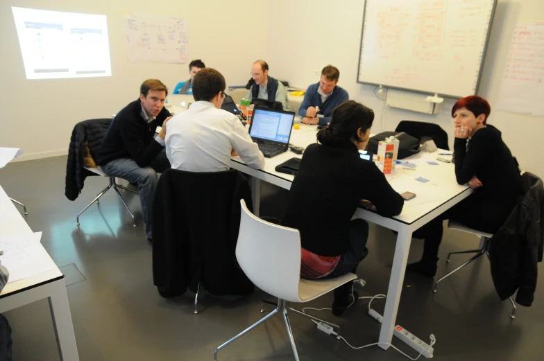 a group of people that are sitting around a desk