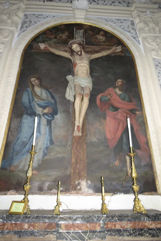 a painting of jesus on a cross and other paintings on the wall