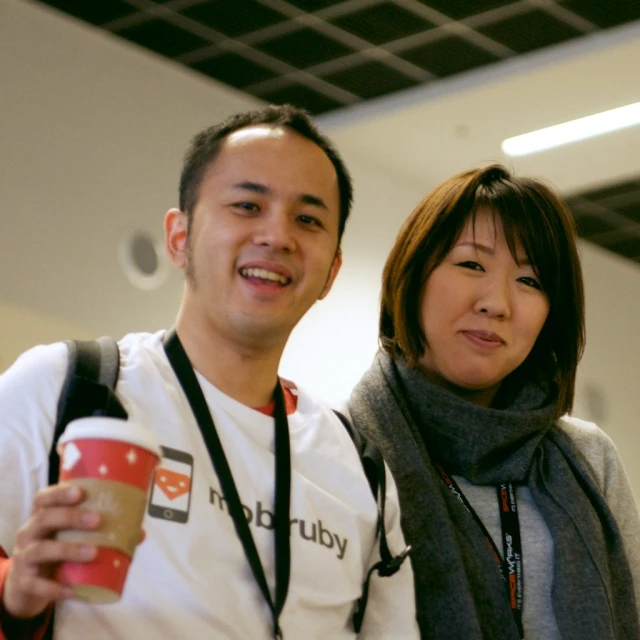 two people posing for a picture holding a cup