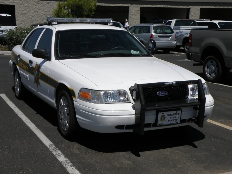a police car parked in a parking lot with others