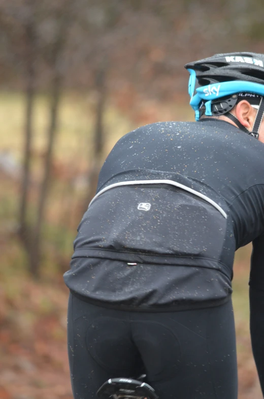 a man wearing a black and blue outfit on his bike