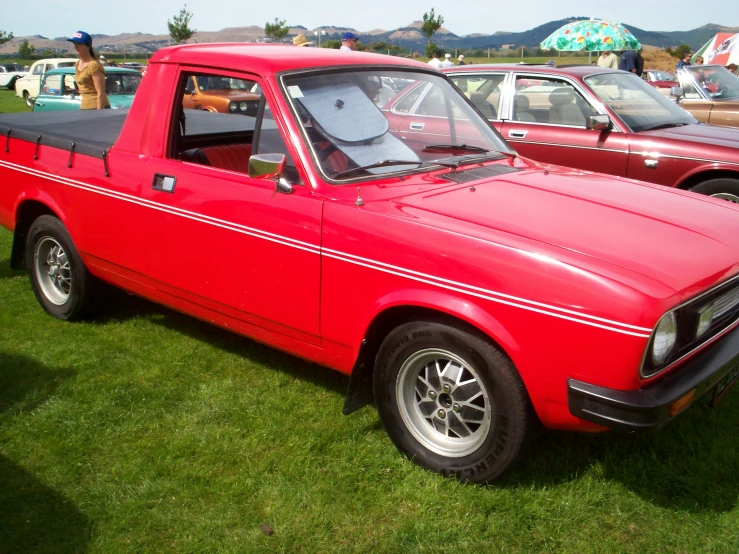 a red truck with a black covering at a car show