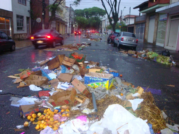 a city street with cars and many debris on the side
