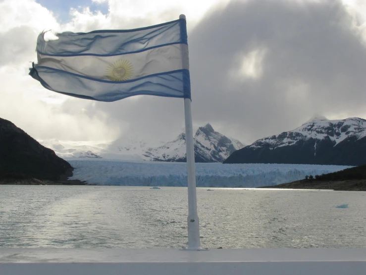 the flag is next to a glacier on water