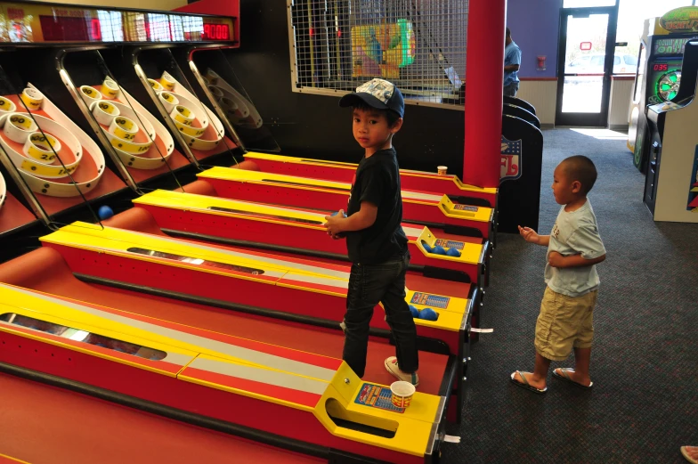 two children playing in the arcade at an infant - friendly play area