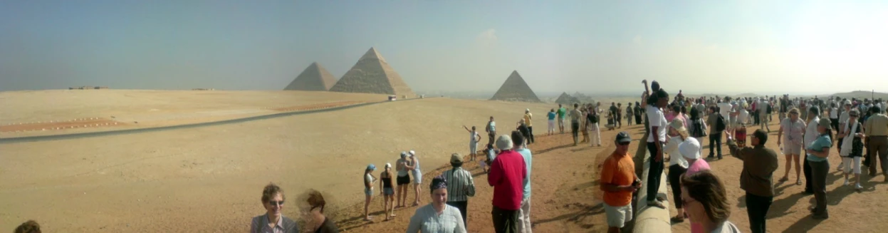 a group of people that are standing near some giraffes