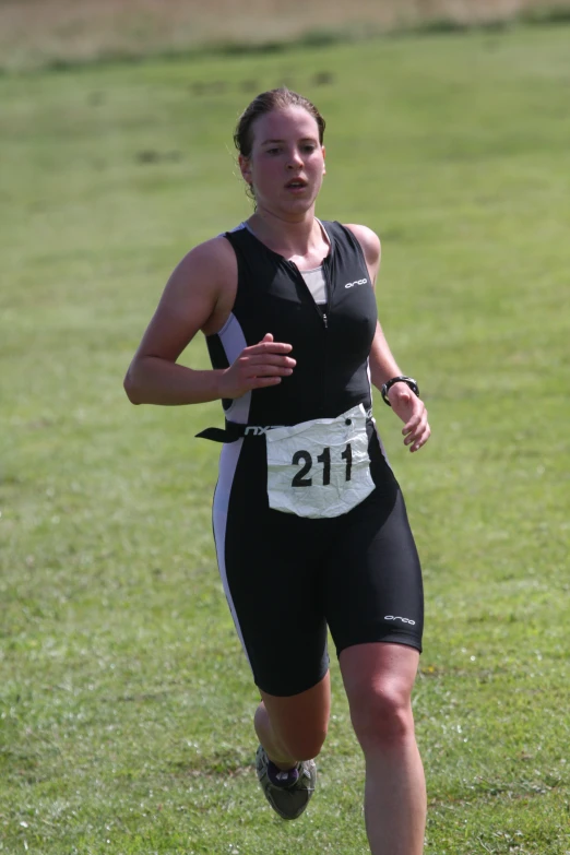 a woman wearing shorts runs through the grass