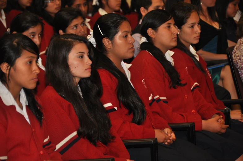 a group of students listening in front of a crowd