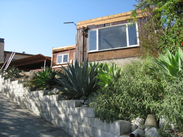 a street in front of a brown house next to rocks