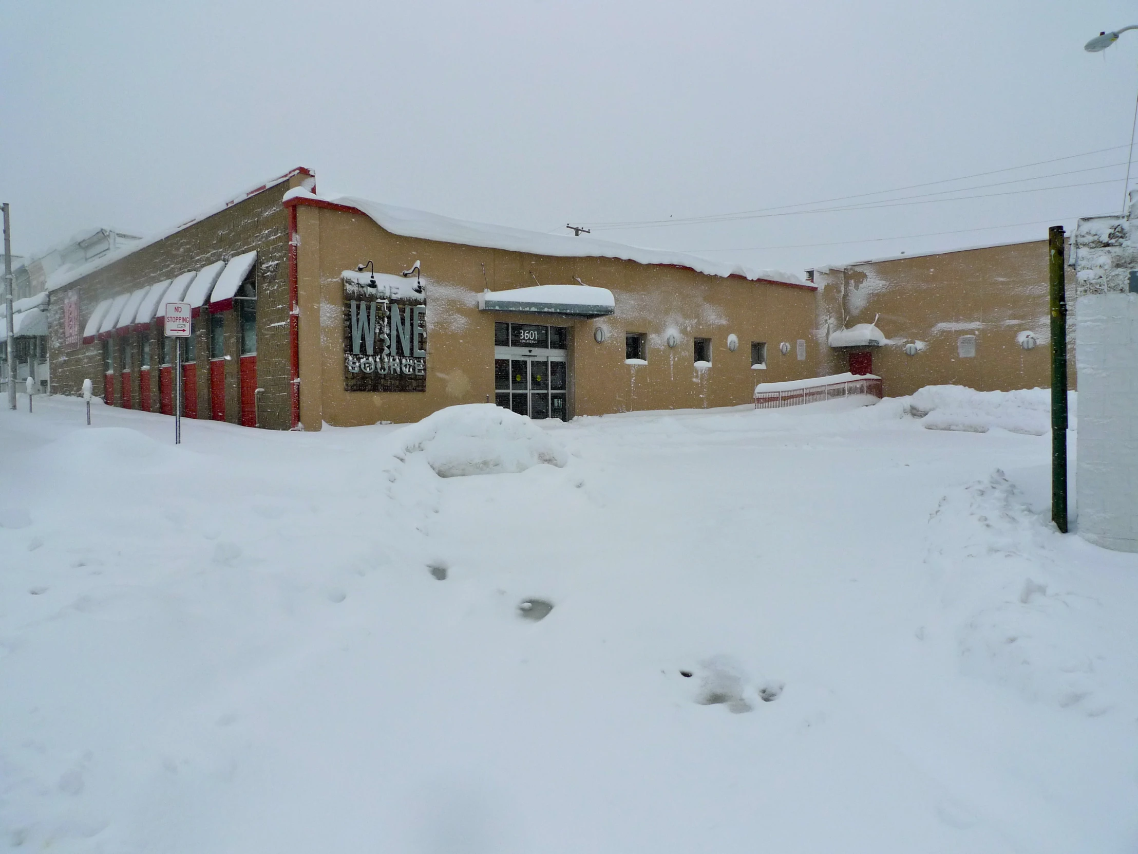 a red building with a clock on the side covered in snow