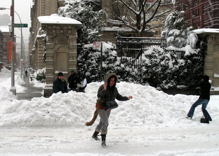 a woman walking down a snow covered street