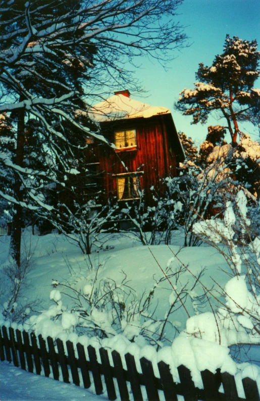 there is snow on the ground and a wooden house