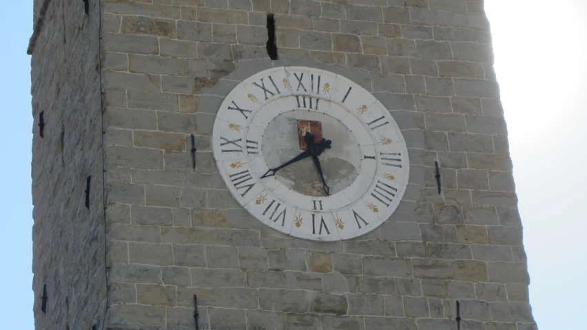 a clock with roman numerals hangs on the side of a brick building