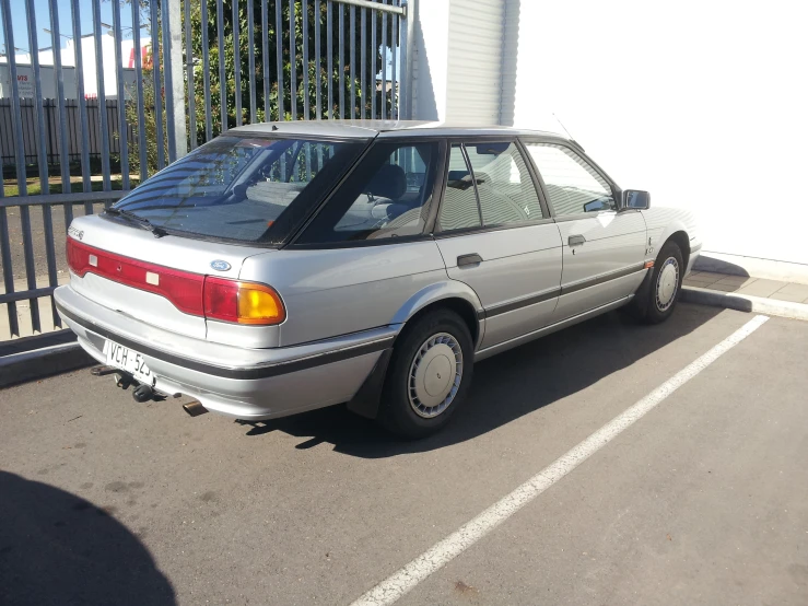 the front of an older model grey car parked in a lot