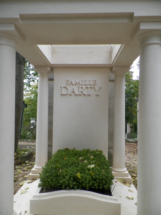 an old grave covered in white pillar with the name of the family