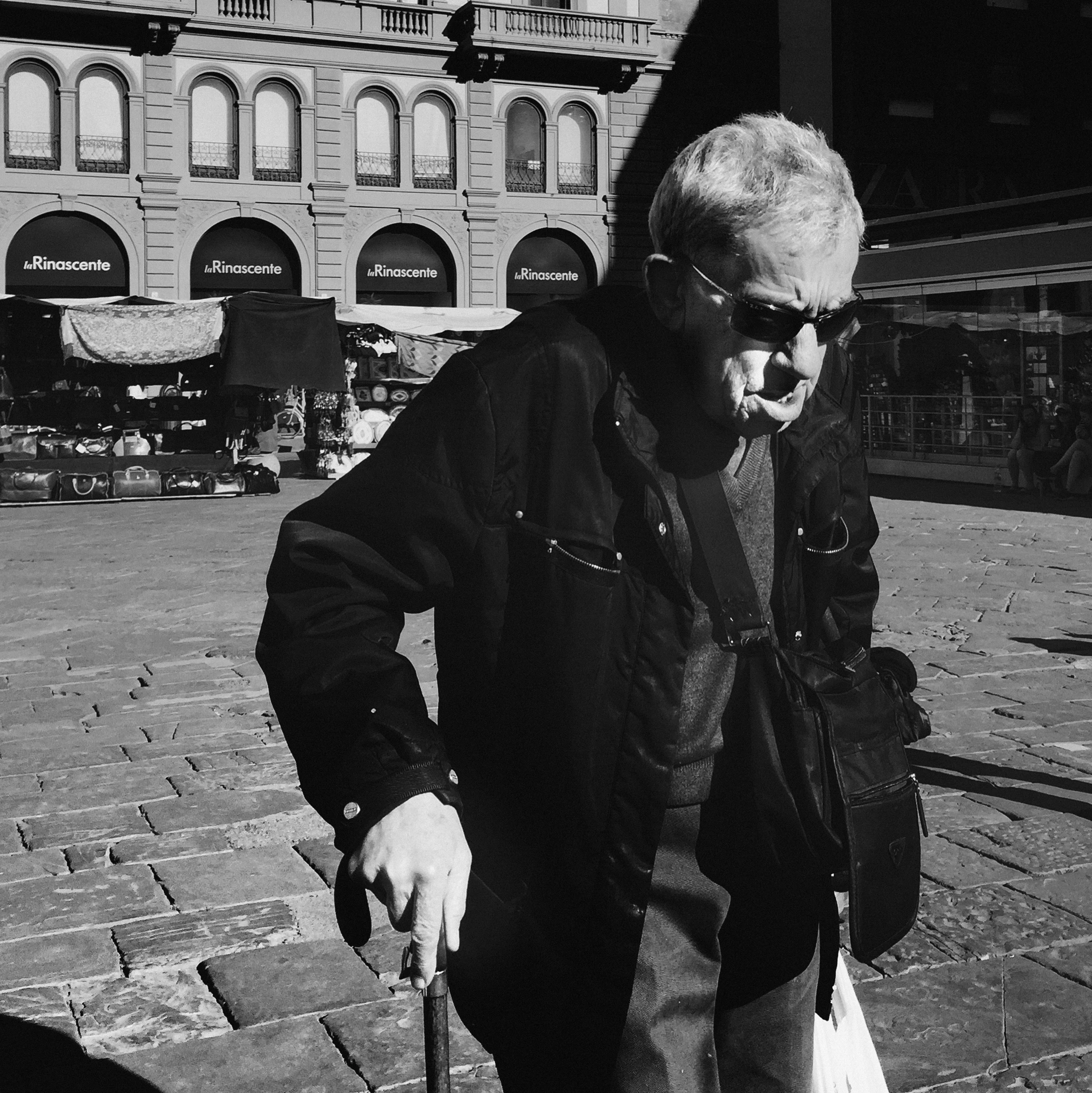 an old man is walking in front of a large building