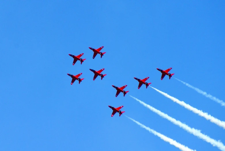 four jets flying in the sky leaving a cloudless trail