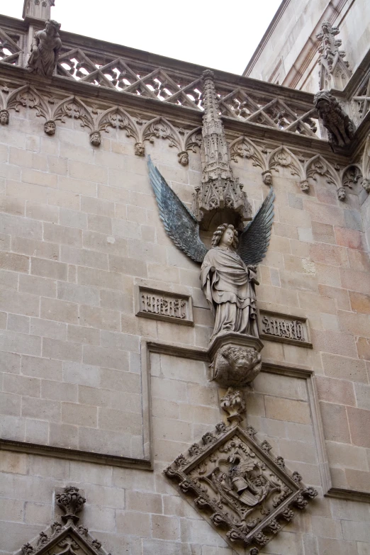 the statue of an angel above the main entrance to a building