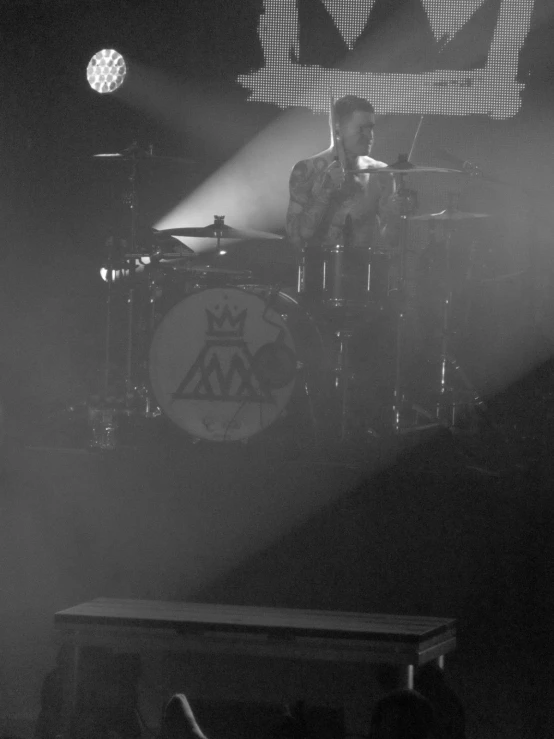 man on stage playing a drum set during a concert