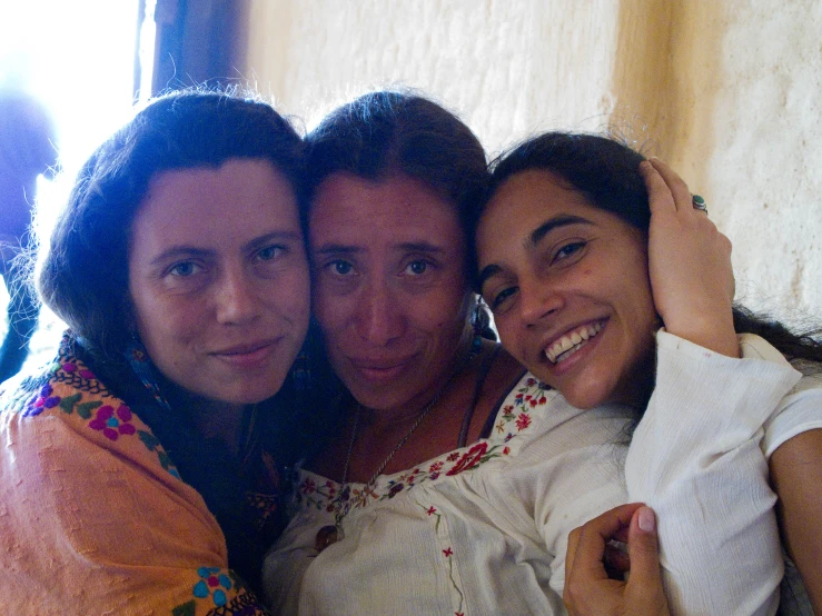 three girls are hugging each other in a group