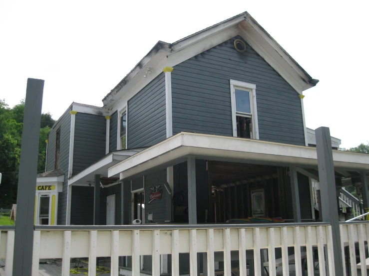 two story grey home with white picket fence