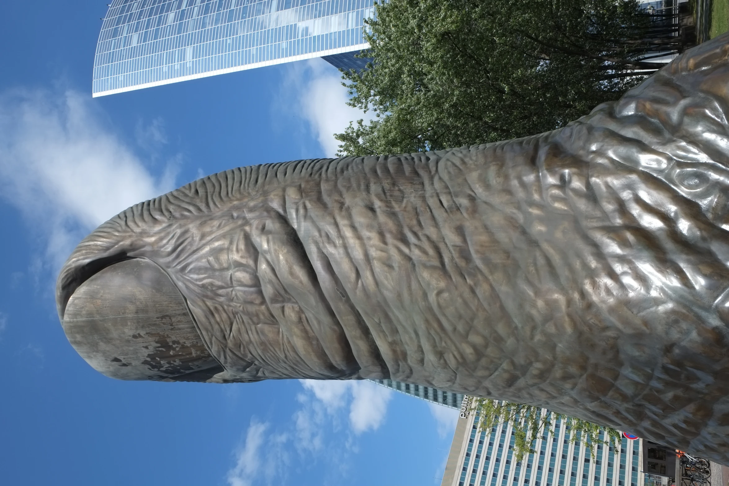 an elephant statue stands outside in front of some tall buildings