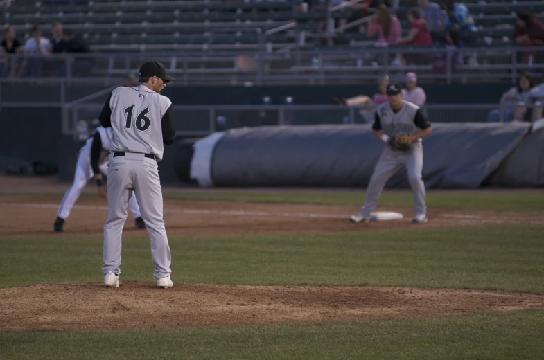 a baseball player standing on top of a field holding a glove