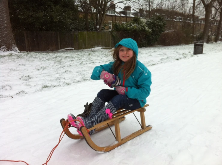 a girl is sitting on a sled that is not skis or snow