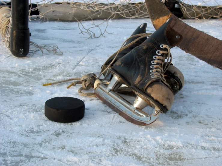an old hockey goalie's hockey glove and stick laying on the ice
