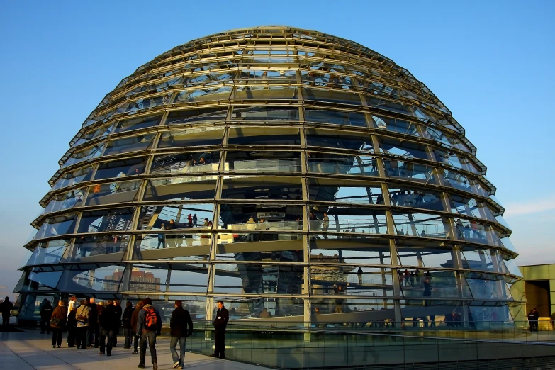 people standing outside of the glass dome building