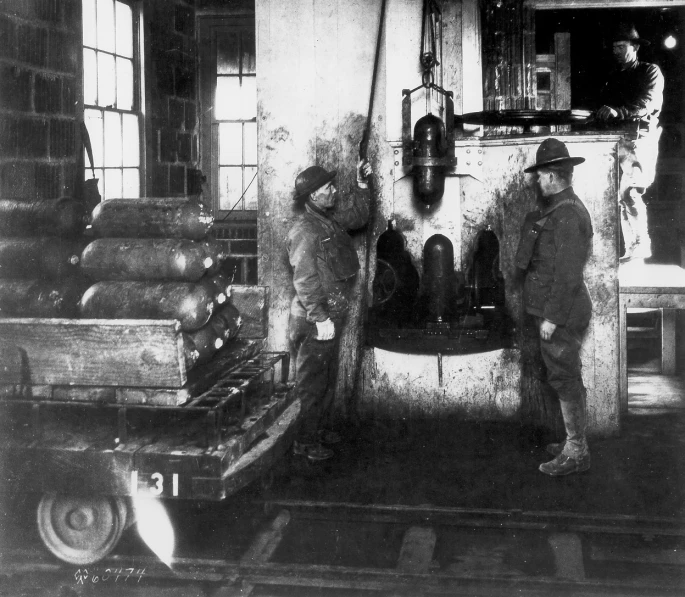 men standing by a machine in a factory working