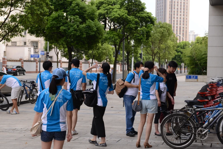 people are walking around in an area surrounded by trees and bicycles