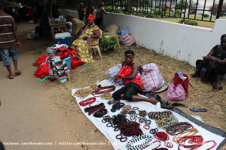 people sit around in front of a table of jewelry