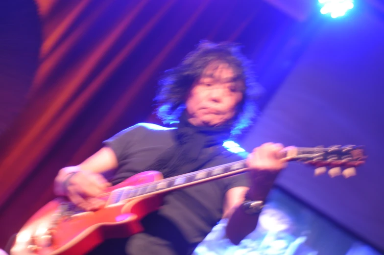 a man plays guitar at a concert at the bar