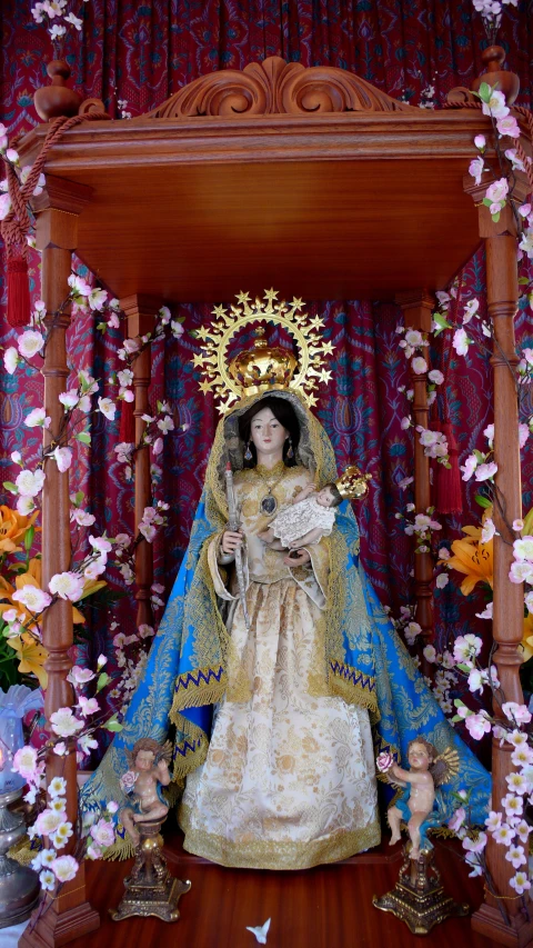 a small statue of a queen in front of a wooden altar