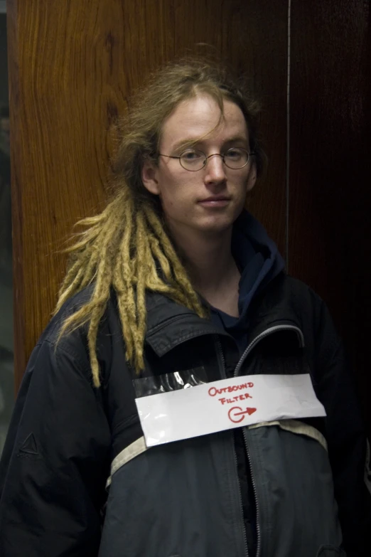 the man with dreadlocks is holding a paper