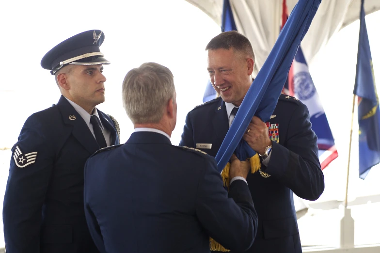 three men standing next to each other and one has a flag