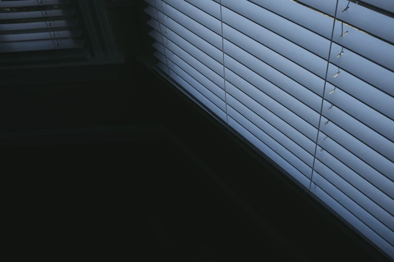 an angled s of a small window with blinds pulled down
