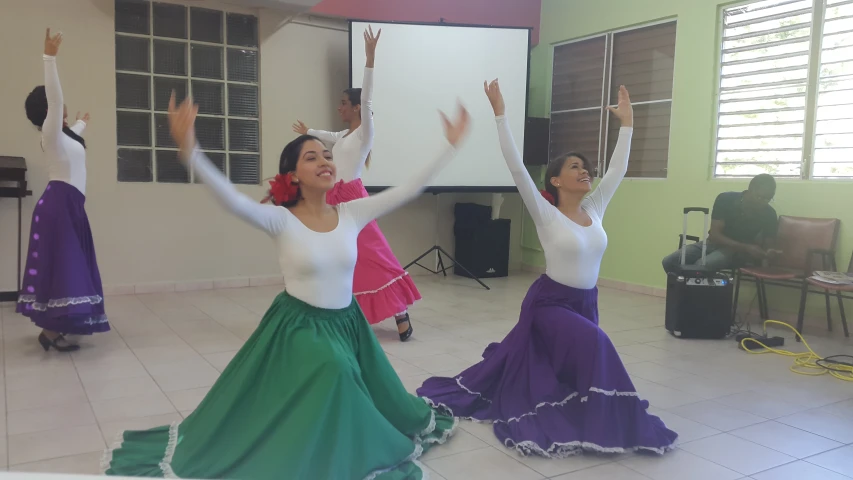 two dancers are posing for the camera while another dancer stands up behind them