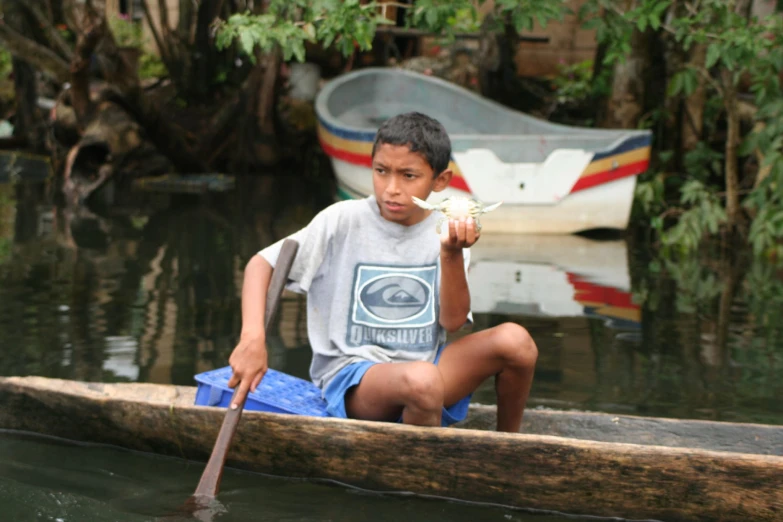 a  sitting in a canoe holding a piece of paper