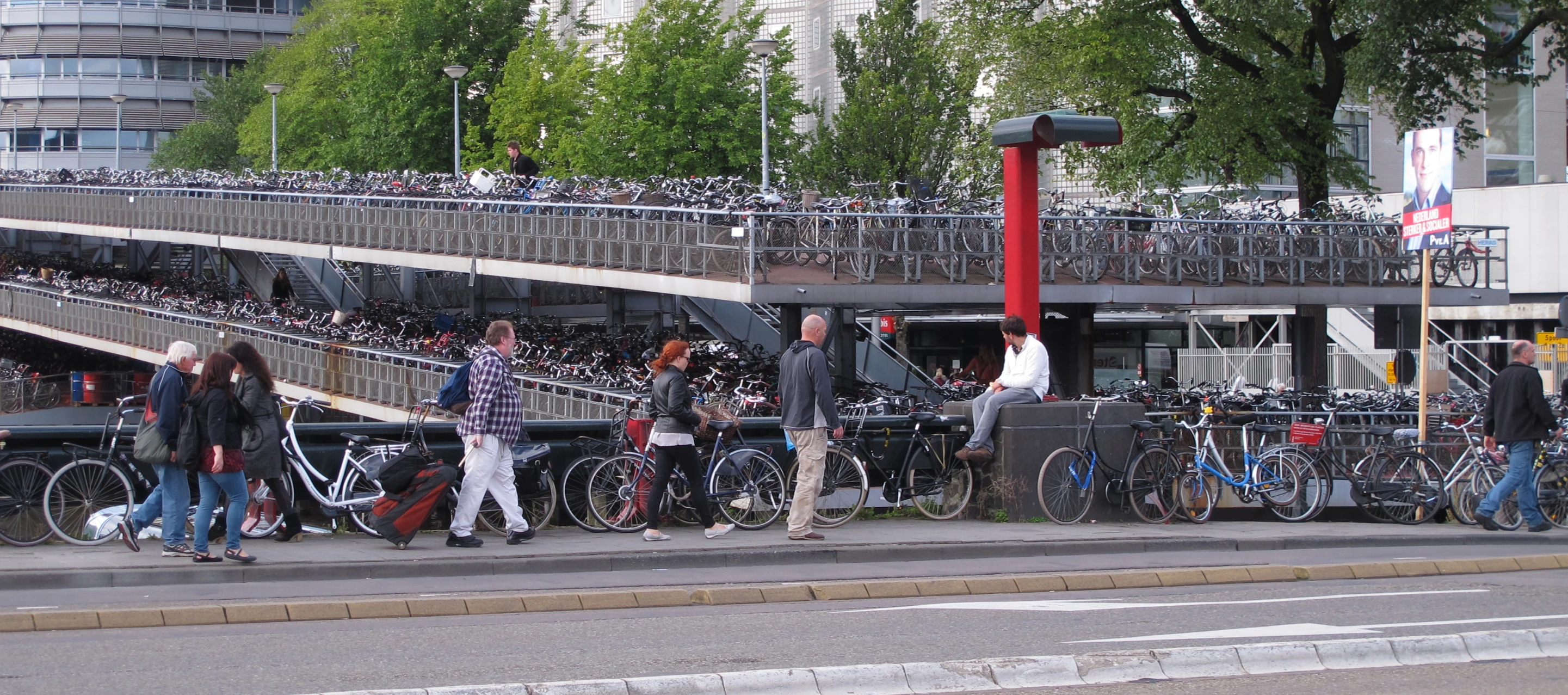 a lot of people are standing at a bus stop