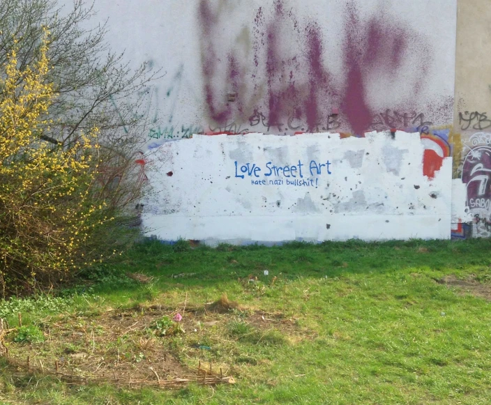 the street sign is displayed near the old wall