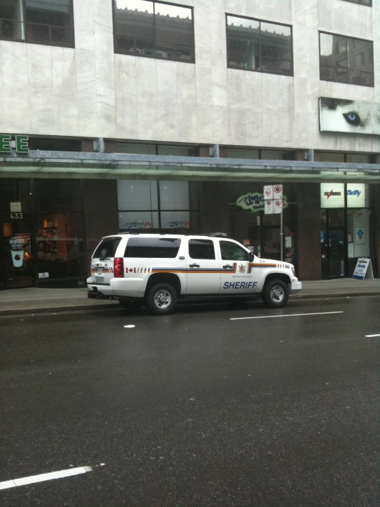 a white sheriff truck is parked on the side of a street